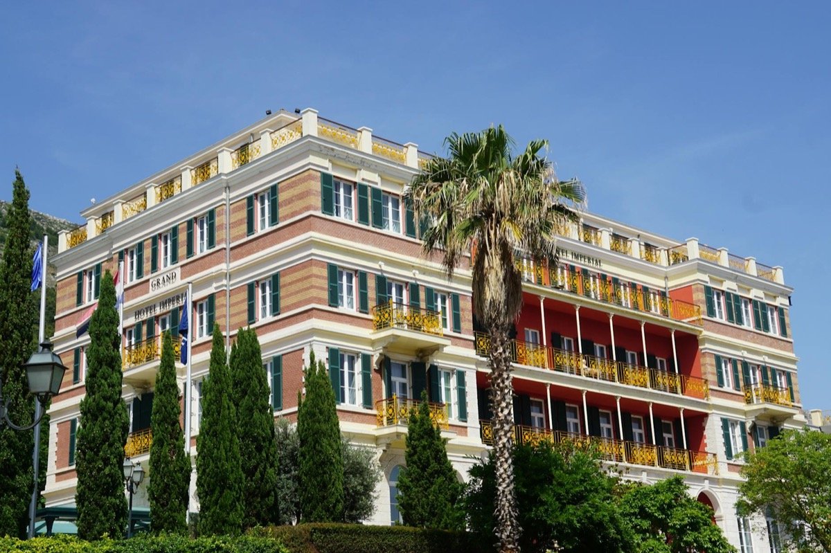 Grand European-style luxury hotel exterior with classical architecture and manicured gardens